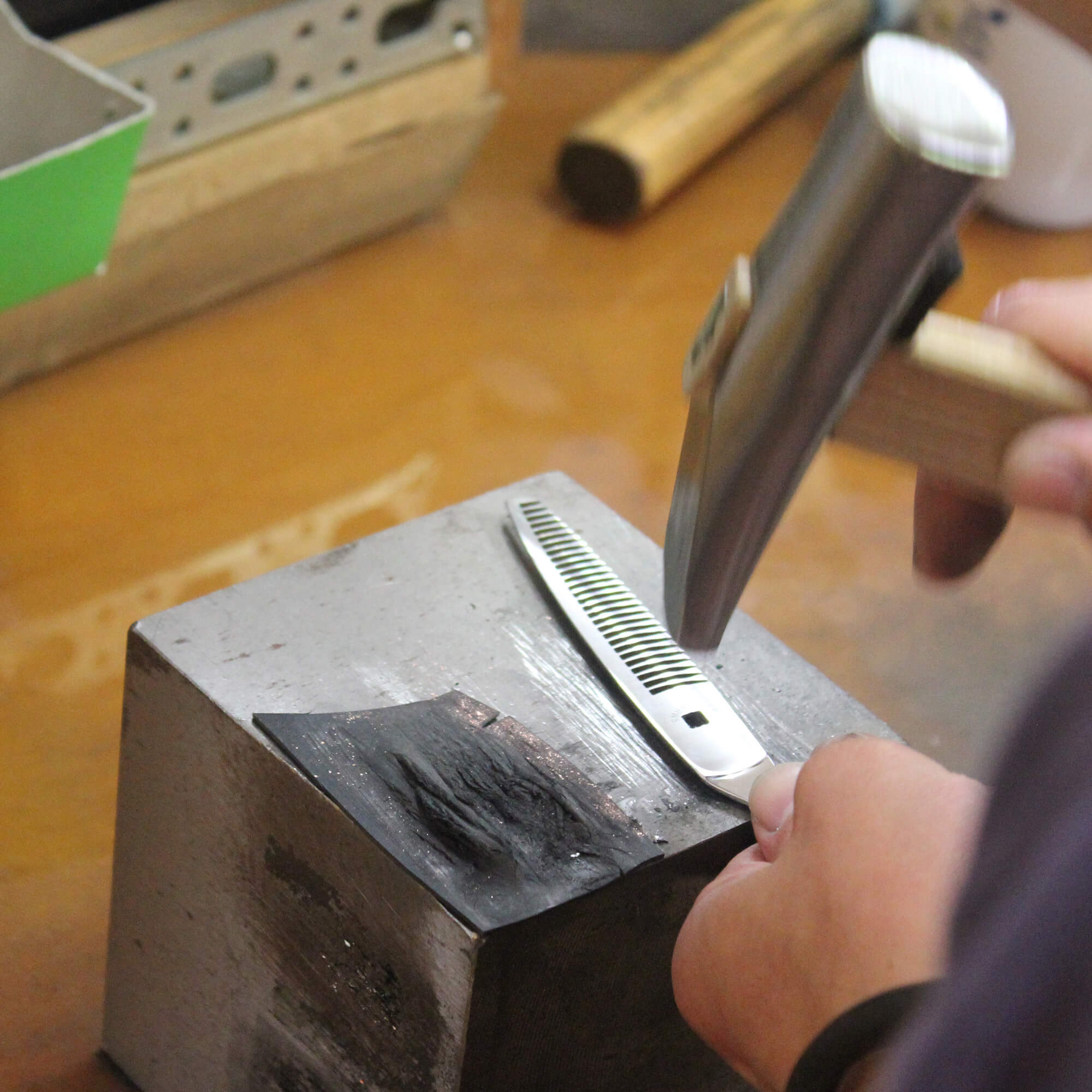 ajustement des lames individuellement au marteau lors d'un affûtage de ciseaux de coiffure