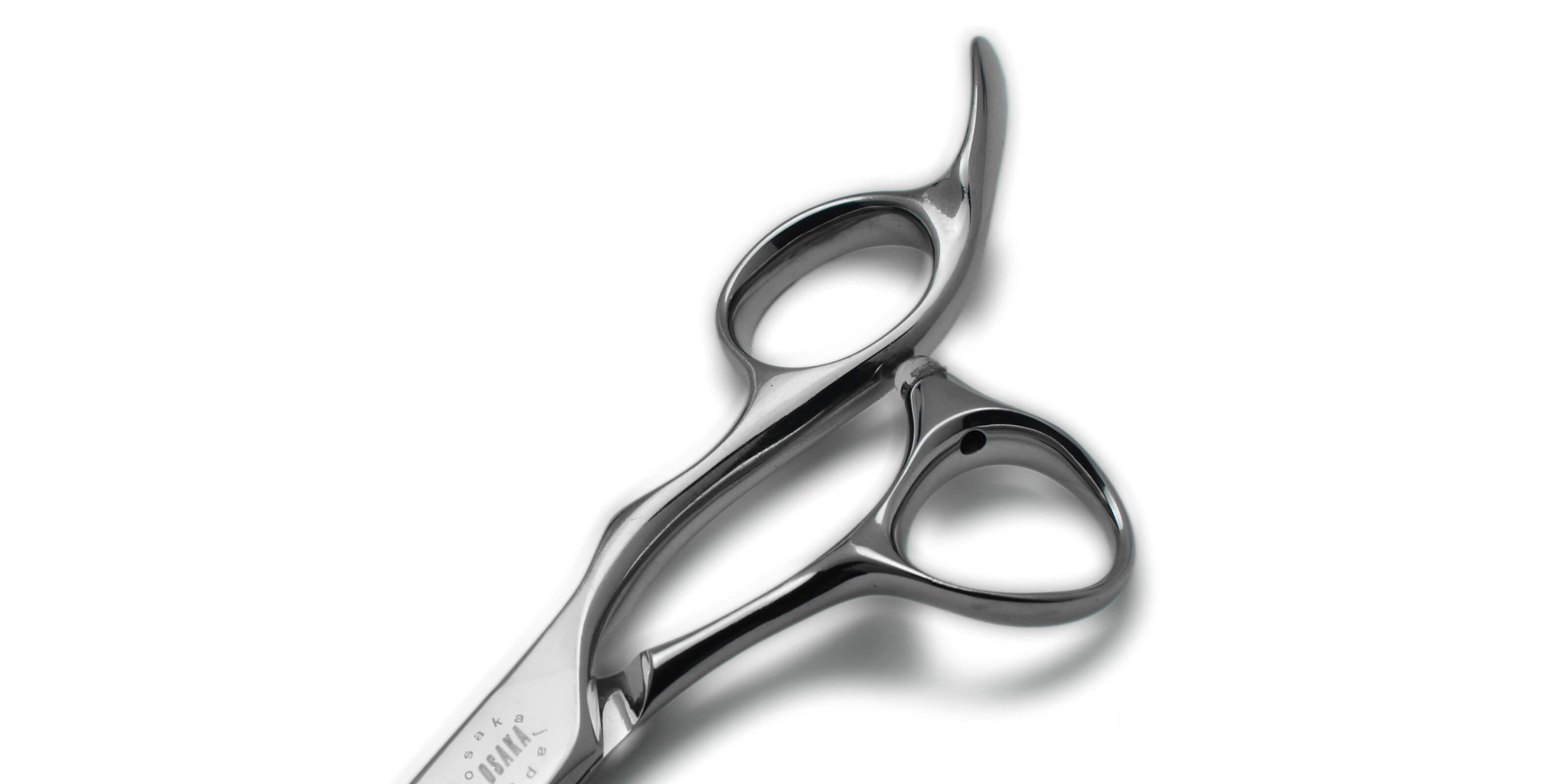 Manche sculpté des ciseaux OSAKA STYLUS, alliant design anatomique et équilibre parfait pour un confort de coupe exceptionnel.