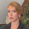 Vidéo de réalisation d’un chignon sur une femme, avec lissage des mèches, structuration des volumes et fixation soignée, illustrant chaque étape de la coiffure de manière professionnelle.