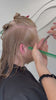 Clara Quesne testant les ciseaux de coiffure OSAKA sur cheveux longs pour une finition nette et élégante.